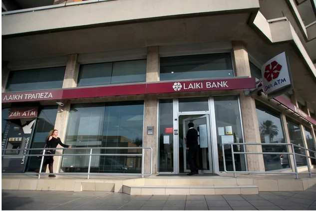 The glass entrance of a Laiki Bank branch with Greek Λαϊκή Τράπεζα signage