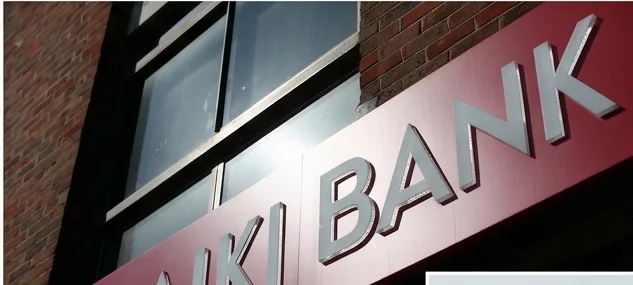 A close-up of the red LAIKI BANK sign and emblem