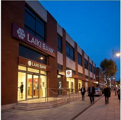 The Laiki Bank UK branch lit at dusk with people walking past